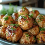 Crispy buffalo chicken meatballs served from an air fryer basket with dipping sauce